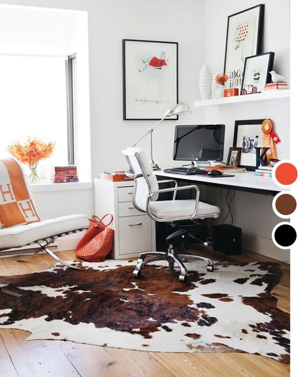 A colorful creative space decorated with a lot of white and a splash of texture in the form of a cowskin rug. 